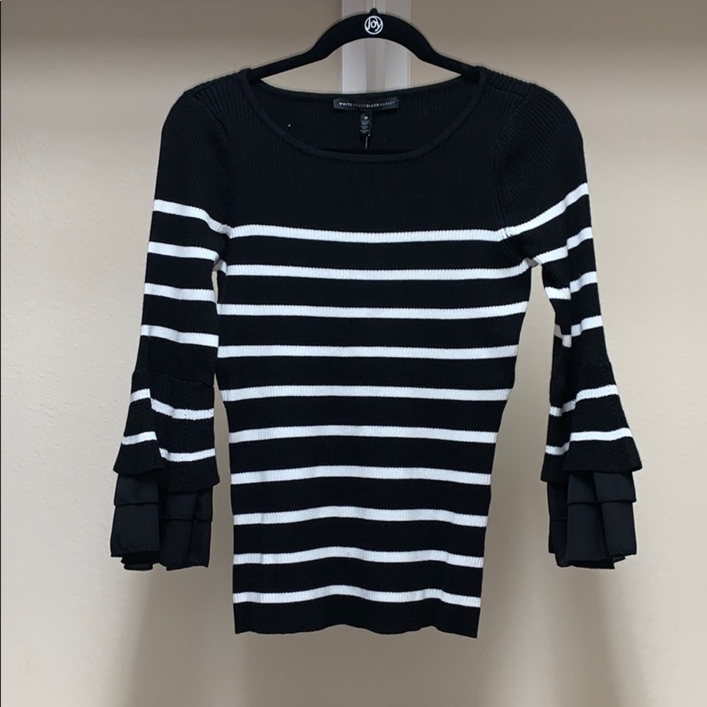 Black and white sweater with bell sleeves.
